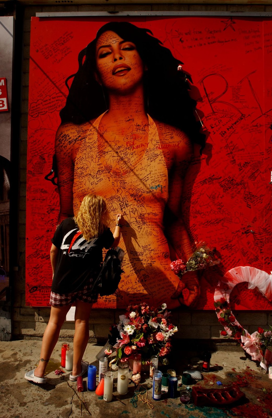 A fan writing a message on a billboard of Aaliyah on August 28, 2001, on Sunset Boulevard in Hollywood, California. | Source: Getty Images